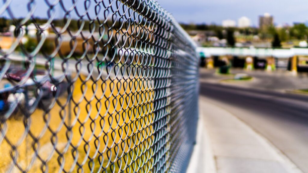 Here's a the chain link fence along the empty lot on a main road. 